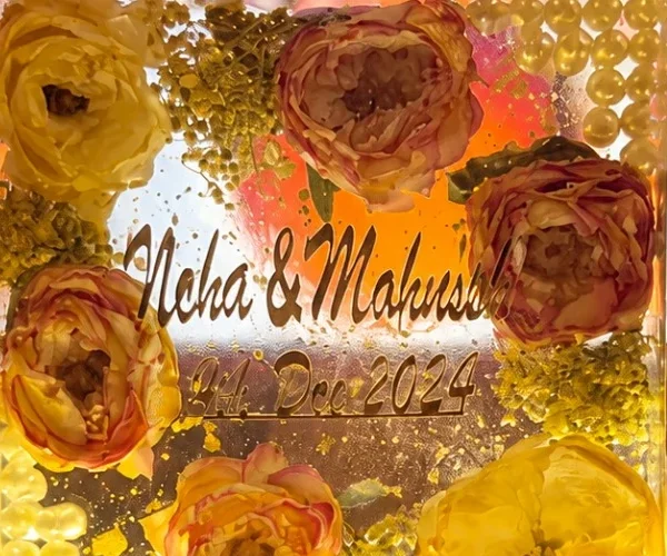 A glowing resin night lamp holding preserved wedding roses, pearls and the couple’s names and wedding date
